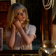 A Anya Taylor-Joy looks in a mirror as Thomasin McKenzie looks on.